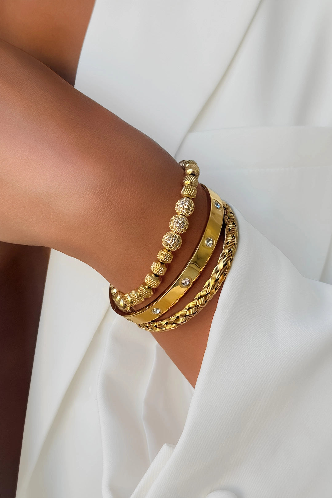 Three-in-one gold stainless steel bracelet styled on wrist – fine jewelry collection piece